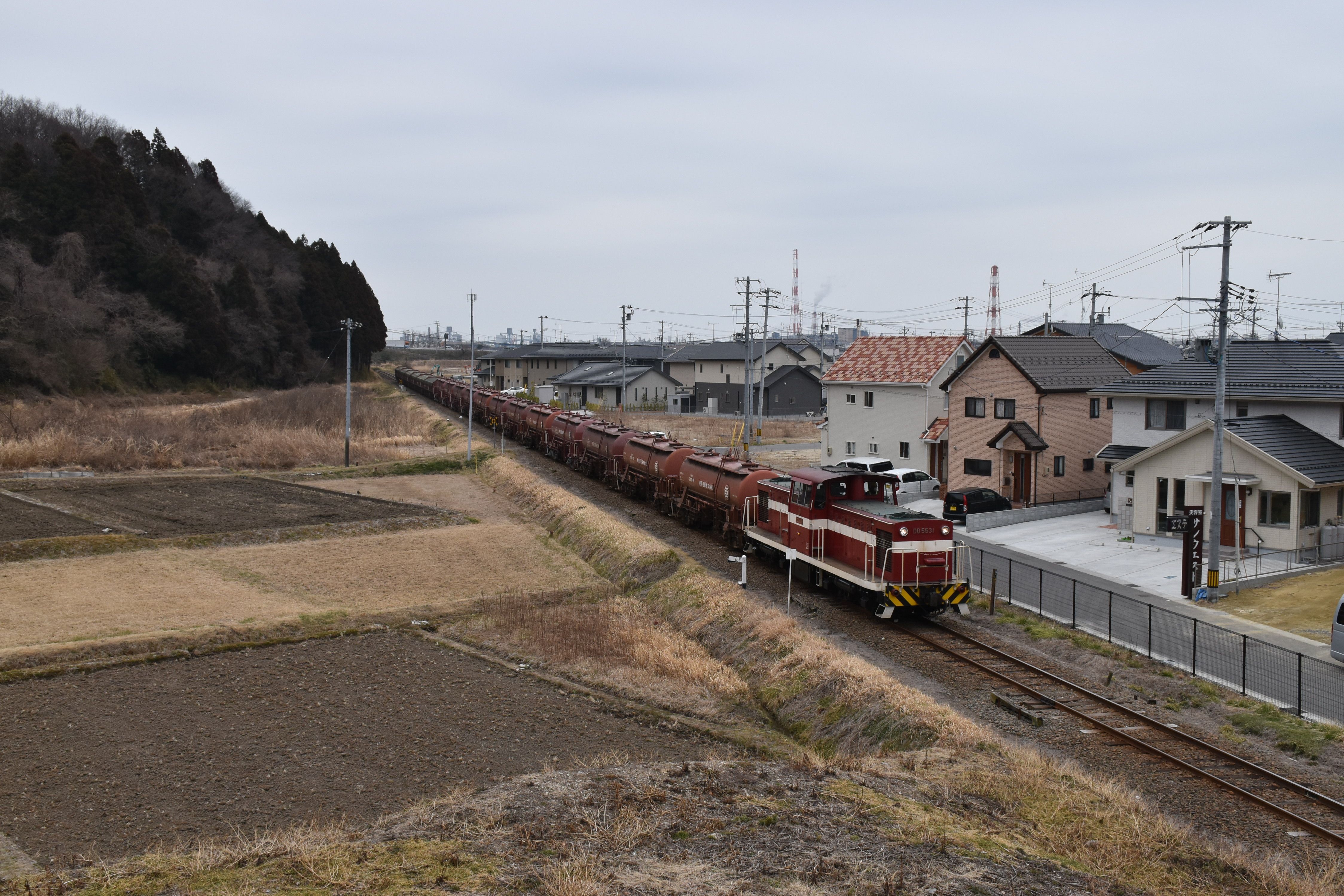 宅地化のなかを泉駅に向かうディーゼル機関車とタンク車(平成28年3月、いわき市撮影)
