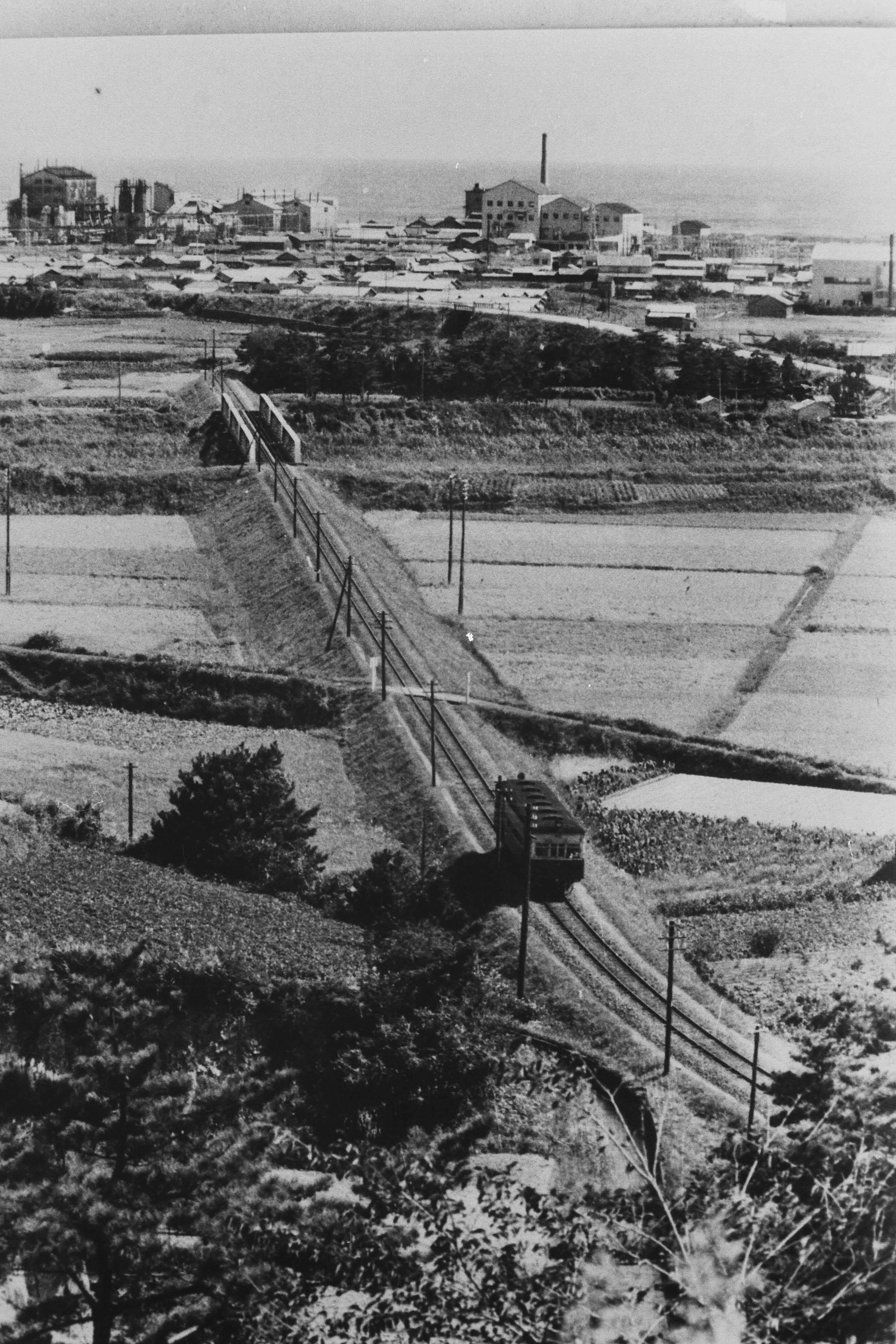 滝尻地内を泉に向かって走る小名浜臨港鉄道の気動車・後に道路との交差部分に滝尻停留所が設けられました(昭和30年代前期、比佐不二夫氏提供)