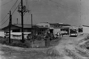 01(旧)勿来学校給食共同調理場(昭和45年5月、いわき市撮影)：施設見学会の参加者がバスを降りたところのようです