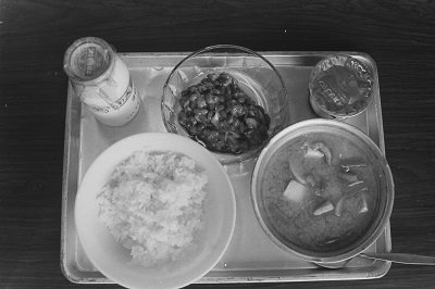 04導入実験期間中の米飯給食の献立(昭和51年2月、いわき市撮影)：ごはん、けんちん汁、納豆和え、プリン、牛乳というメニューのようです