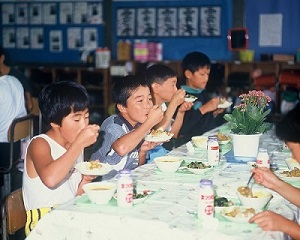 06ポリカーボネート製の新食器による試食会・永戸小学校(平成4年8月、いわき市撮影)：手に持っても熱くない新食器でのメニューはカレー！おいしそうに食べてます