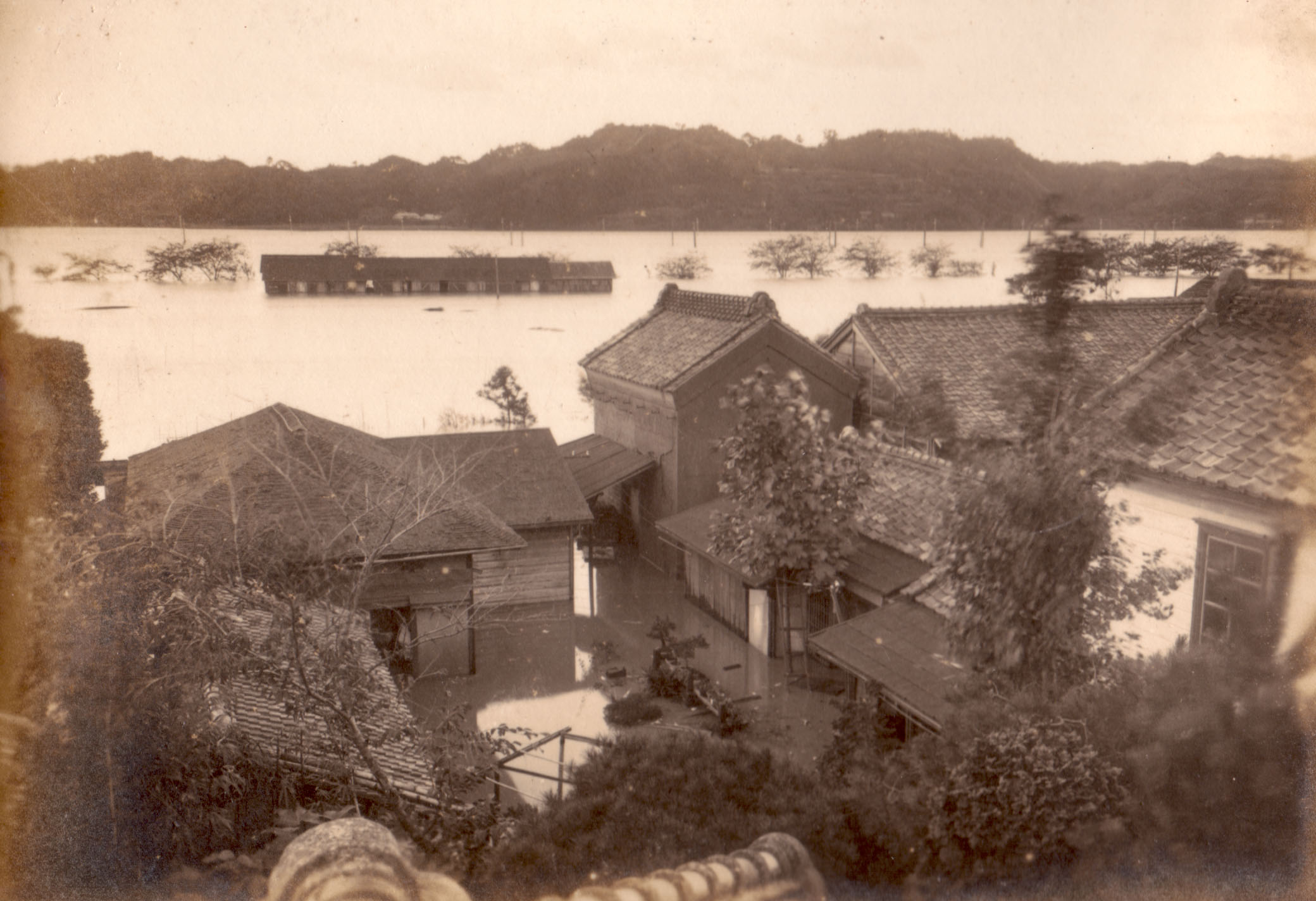写真01 新川流域の洪水　水没した遠くの小屋が後の大黒屋(現平字中町)付近。第1回国勢調査が行われた日で、「国勢調査水害」と呼ばれました。〔大正9(1920)年10月、真木隆四郎氏撮影 〕
