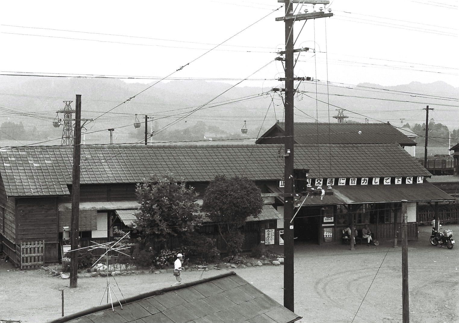 写真6　小川郷駅舎を広場を挟んで向かい側の建物屋上の高みから見る架空索道(昭和30年代後期、国府田英二氏提供)
