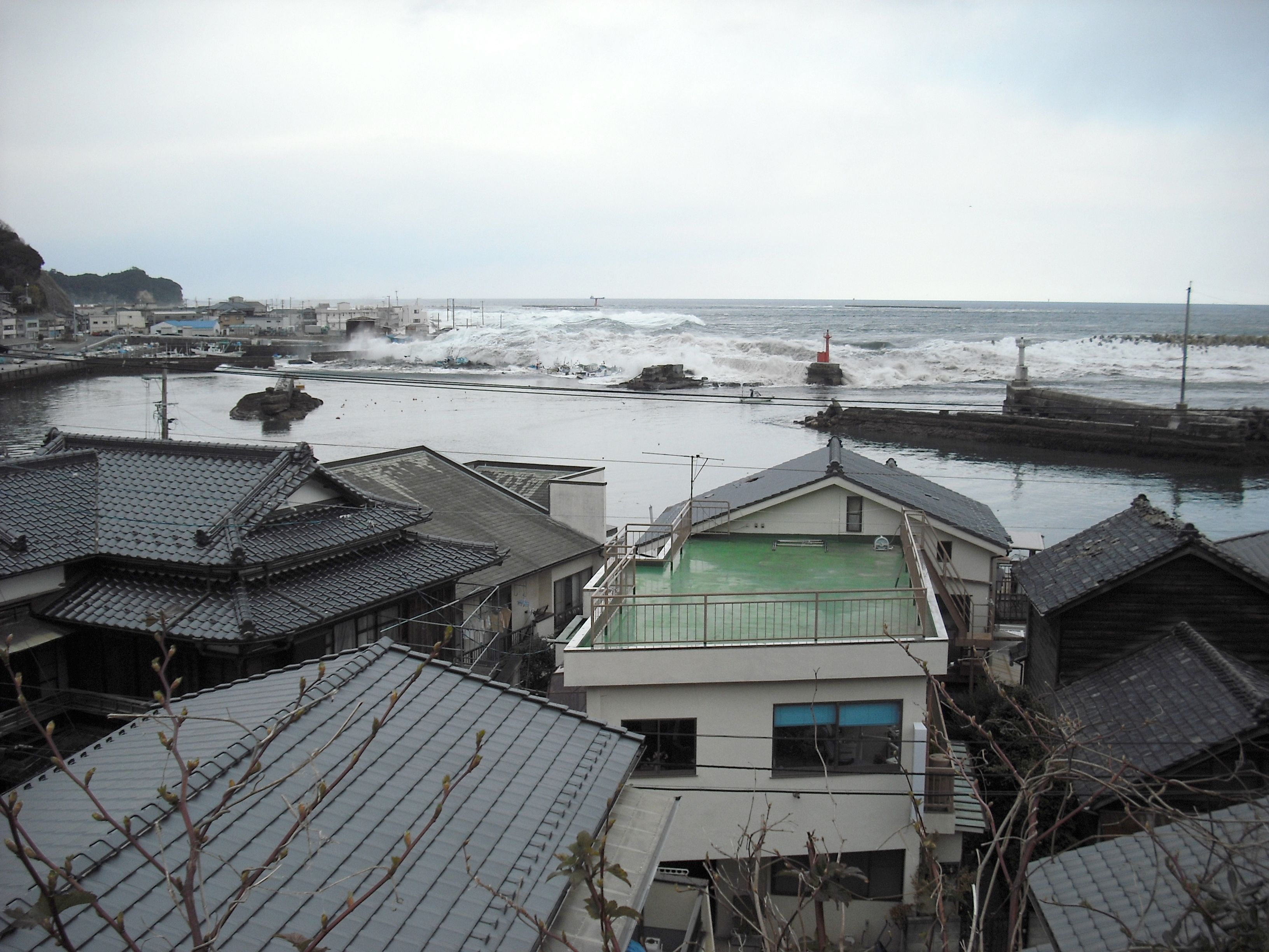 南側高台から見る中之作港に押し寄せる大津波〔平成23(2011)年3月11日午後4時2分、松本茂氏提供〕