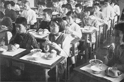 給食風景4・勿来市内の小学校（昭和39年版なこそ・市勢要覧）：メニューは脱脂粉乳、勿来パン工場製のコッペパン、汁物のようです