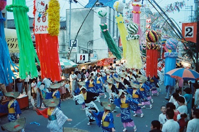 08_いわきおどり・平本町通り(昭和57年8月、いわき市撮影)：制定翌年の夏の大会です。この年のみ平本町通りで開催されたので、平七夕まつりの吹流し飾りとの共演が見られました