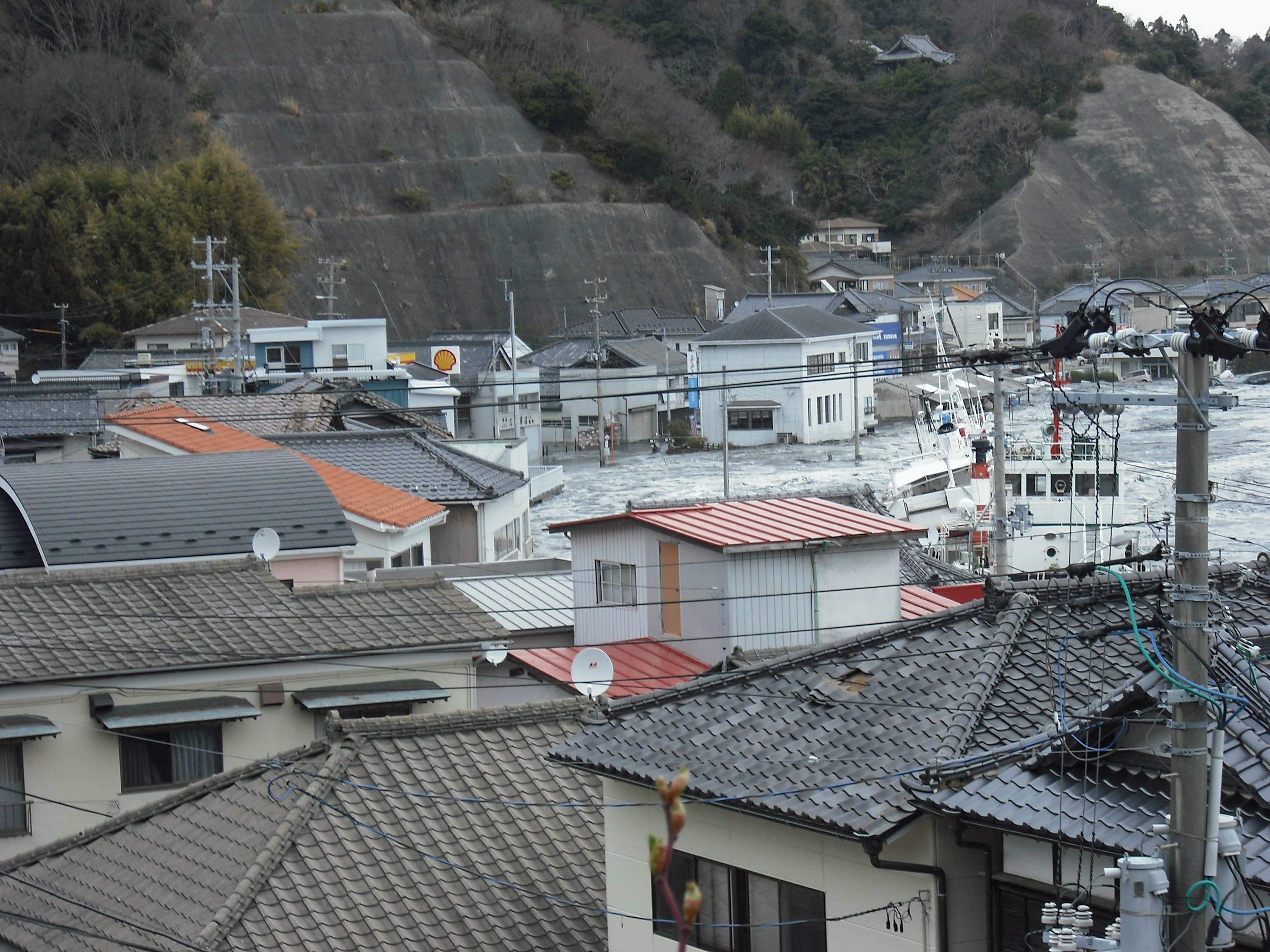 南側高台から見る中之作港に押し寄せる大津波〔平成23(2011)年3月11日午後4時5分、松本茂氏提供〕