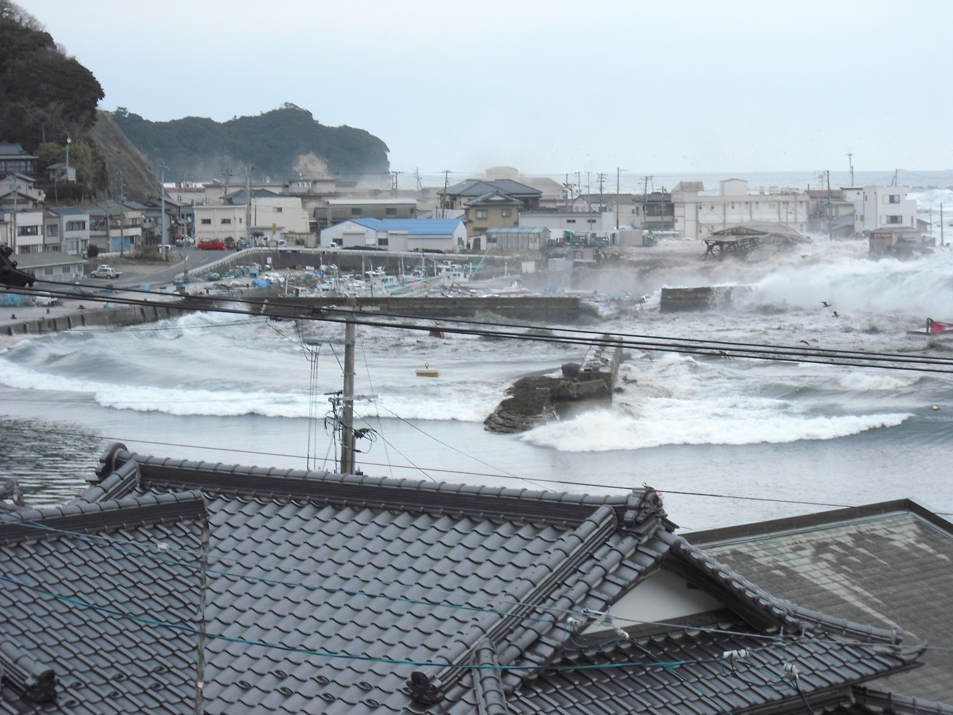 南側高台から見る中之作港に押し寄せる大津波〔平成23(2011)年3月11日午後4時3分、松本茂氏提供〕