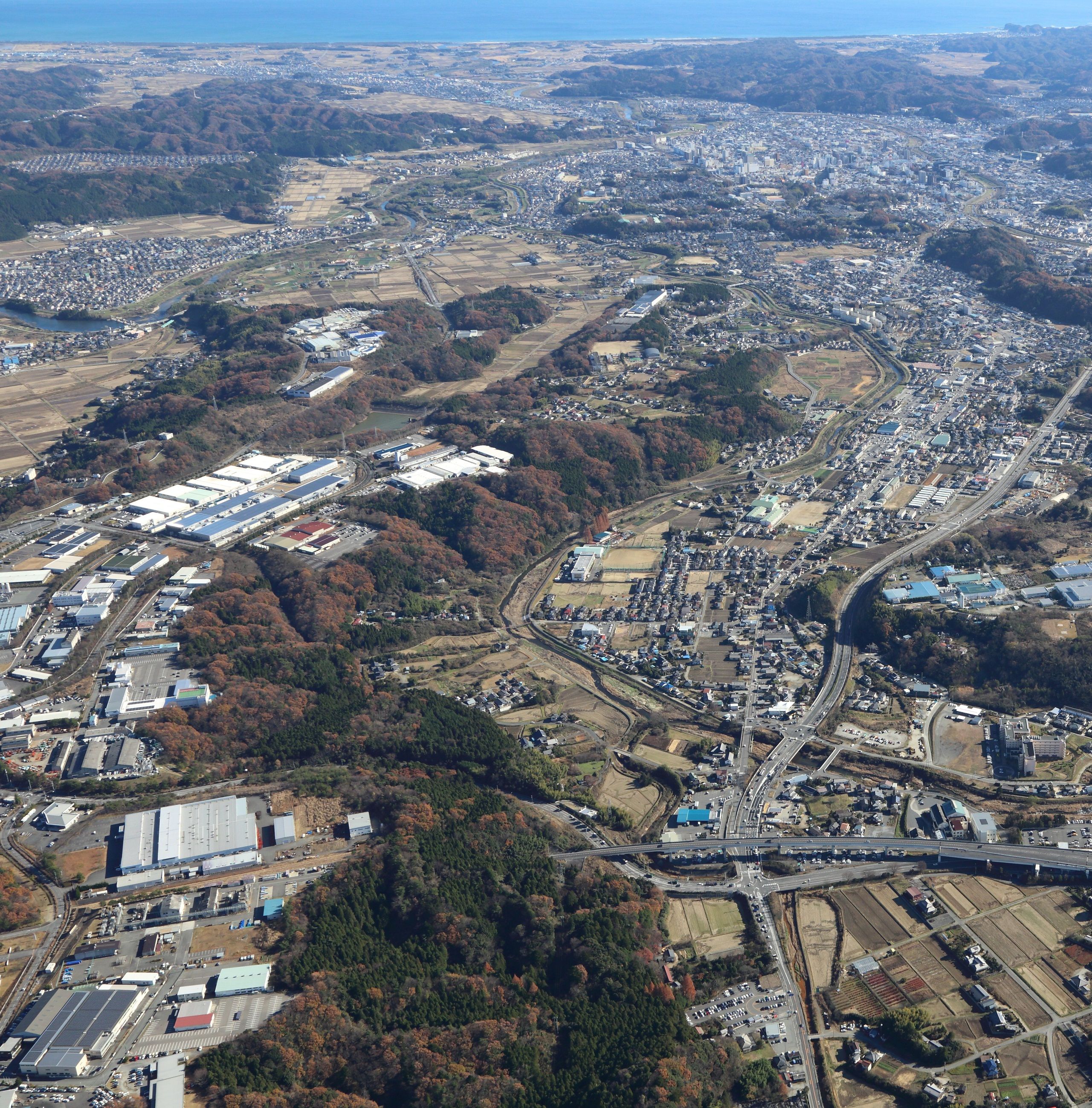 ■写真3-2 常磐自動車道いわき中央IC(写真手前)に接する「いわき好間中核工業団地」〔平成26年(2014)12月 いわき市撮影〕