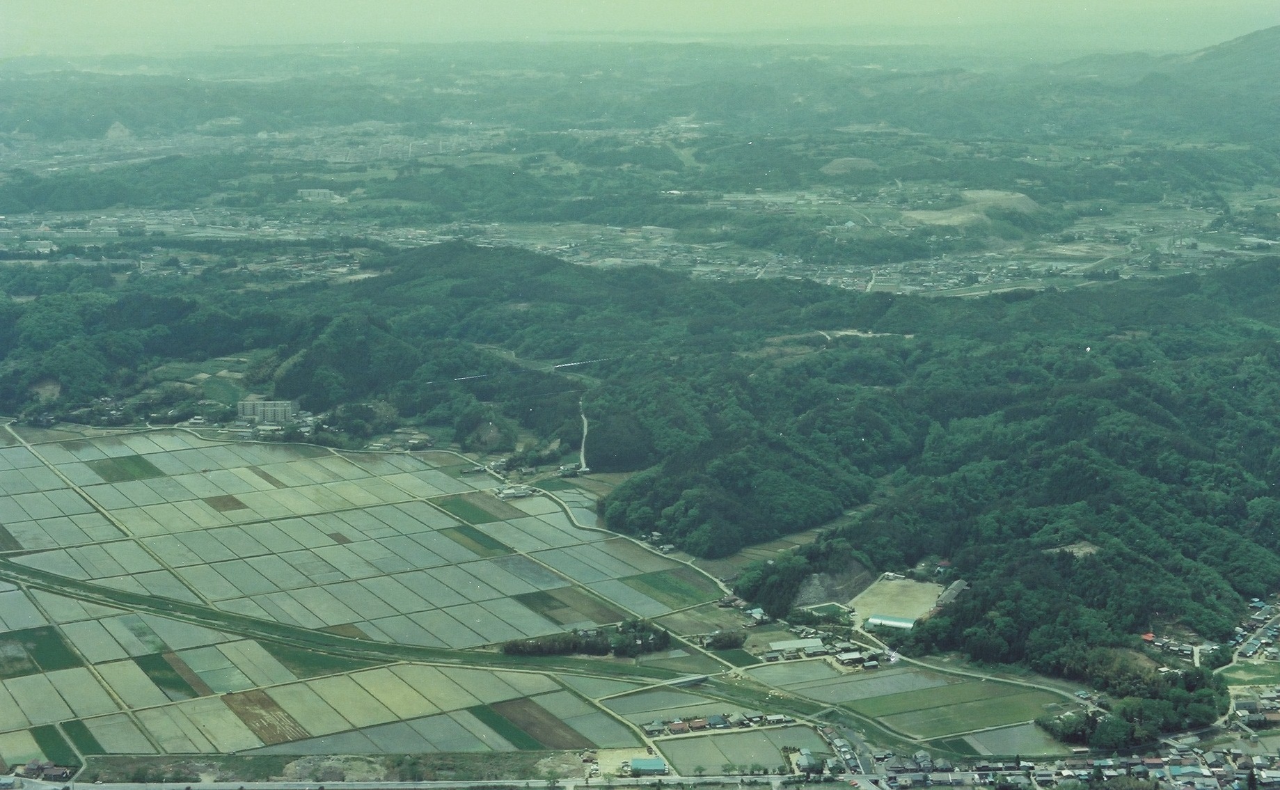 ■写真2-1　工業団地建設予定地を北側の平赤井から遠望　〔昭和55年(1980)頃  いわき市撮影〕