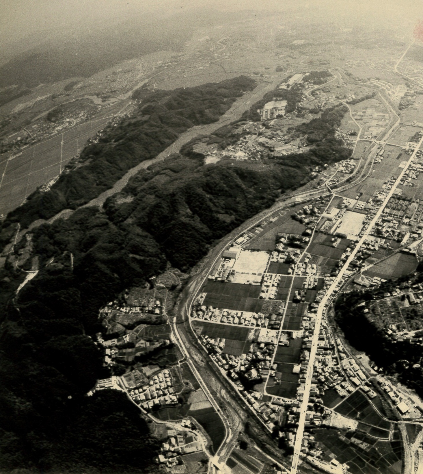 ■写真3-1　工業団地建設予定地（写真左）と好間市街を西側から遠望　〔昭和50年代　稲葉廣巳氏提供〕