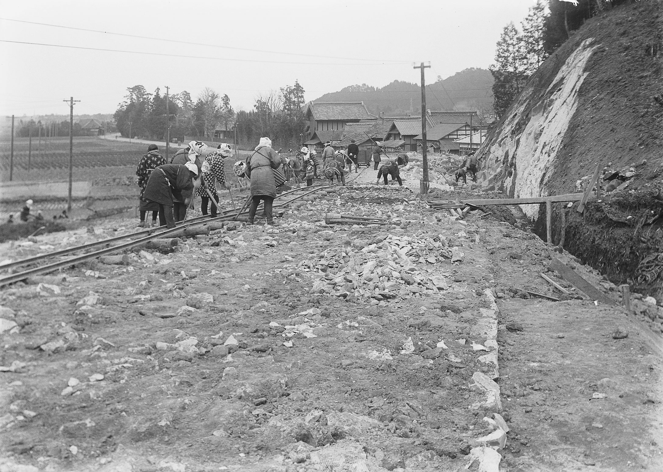 ■写真1-1 鎌田山切り通し工事と、遠方に塩集落　〔昭和10(1935)年頃　磐城国道事務所提供〕