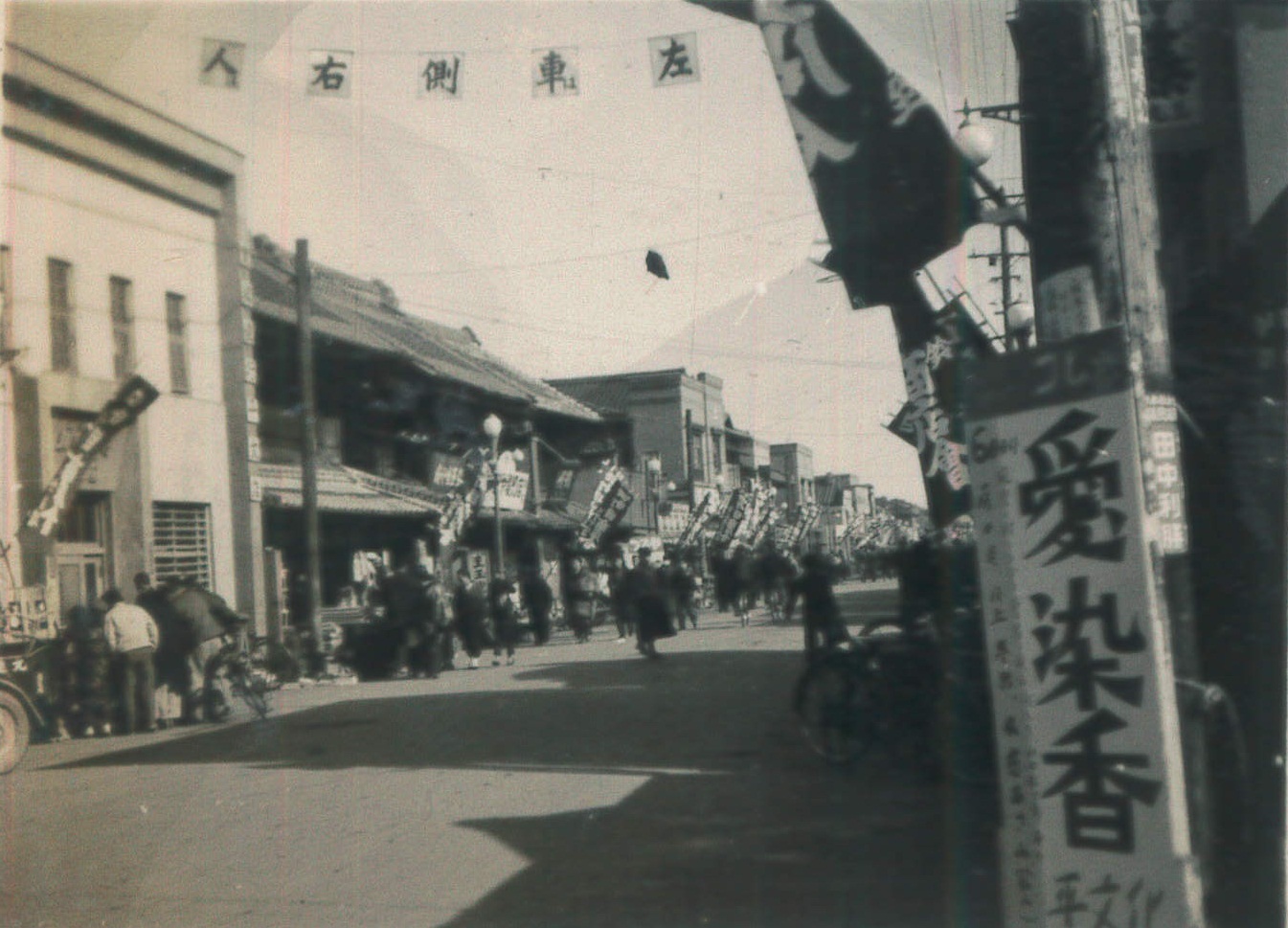 ■写真2-1  平本町通りの四町目(写真左が茨城相互銀行平支店)から東方を見る・新しい交通ルール「人は右、車は左」の横断幕が見える(昭和29年頃　稲葉廣巳氏撮影)