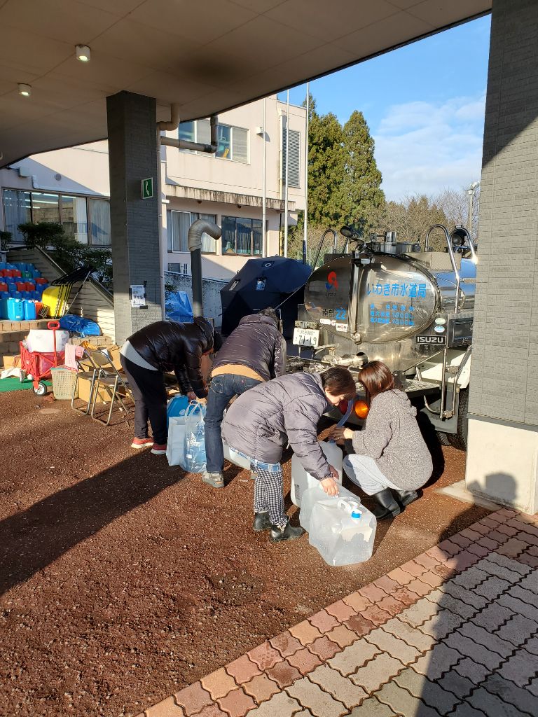 被災された方々が給水車から水を汲む様子