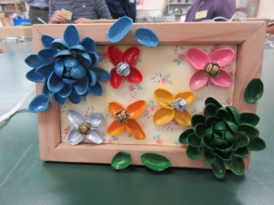 ピスタチオの殻を使った青と緑の花のフレームアートの写真