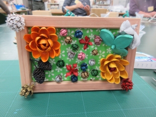 ピスタチオの殻を使ったオレンジと黄色の花のフレームアートの写真