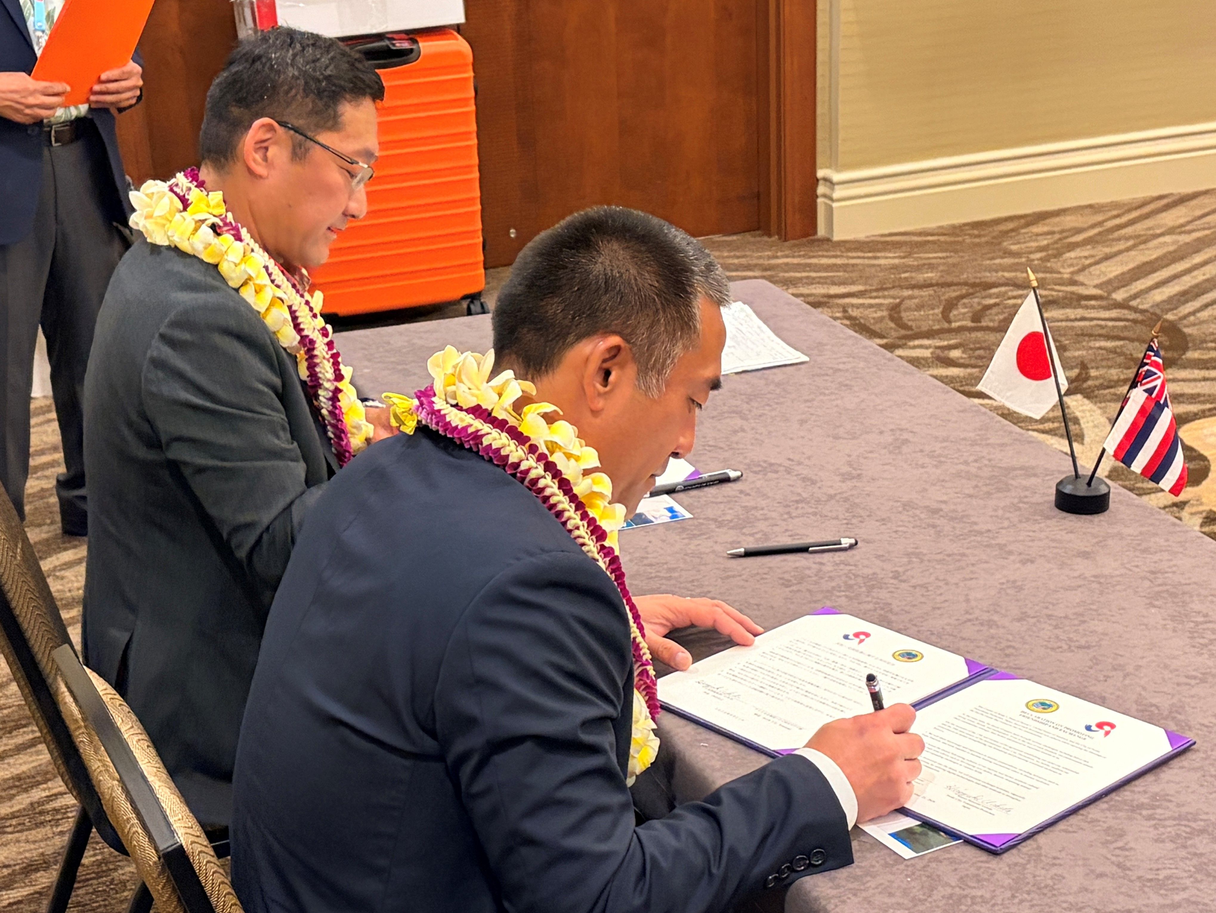 共同宣言書に署名する内田市長とカワカミ郡長