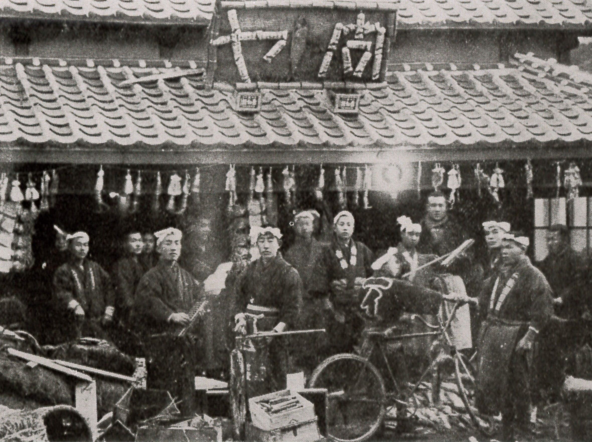 四町目の魚問屋「吉伝」。看板の「問ヤ」は荷造り箱の廃物利用。店頭には塩サケ、スルメがせぶらさがっている。(大正時代 『いわき商業風土記』)